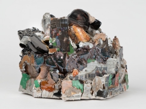 A mixed clay sculpture with black and green lusters, decals, and digital images