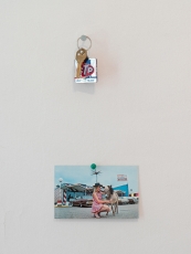 An installation that shows a postcard hung below a set of keys