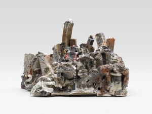 A mixed media sculpture with gray, white, orange tones