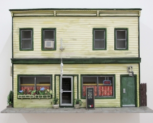 A photograph of the facade of the building that housed Callicoon Fine Arts in Callicoon, NY, made from foam core and paper. It is a yellow building with green trim and doors. There is an Italian restaurant on the first floor.