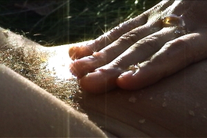 A film still of a hand touching skin