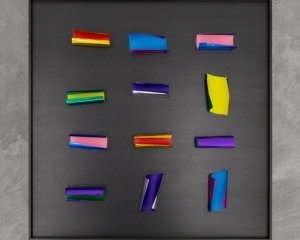 An overview photograph of pieces of colored papers on a black background