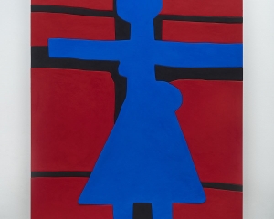 A photograph of a predominantly red surface with a blue figure shape in the center, arms outstretched, with a triangular bottom section. There are black lines that define a cross behind the figure.