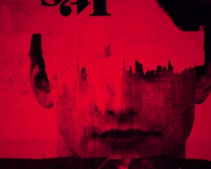 An image of red and black the depicts a male face, with graffiti and portions ripped away.