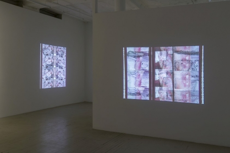 A photograph of two Luther Price video projections. In the foreground on the temporary wall we see images of an abstracted body parts; on the far wall to the left we see a body on the operating table.