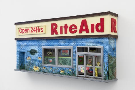 The facade of a Rite Aid with a mural upon it. There is a sign that says "Open 24 Hours," and the majority of the facade is blue and green. There is a sliding door, and 2 windows. The work is hung on the wall.