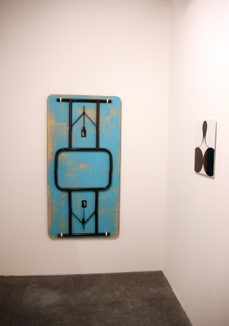 A folding table hung on the wall, painted blue, and one of M&uuml;ller's enamel paintings at right
