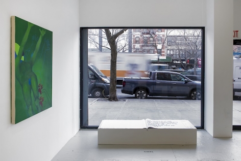 An installation view of Ranee Henderson's green painting and Shawné Michaelain Holloway's book in front of the gallery's main window
