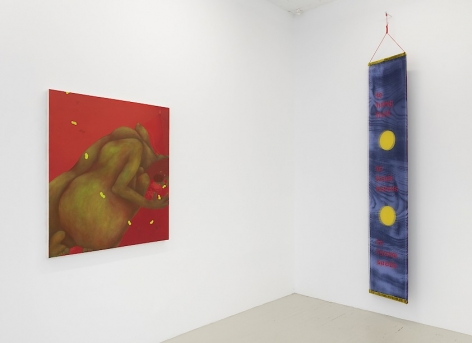 An installation view of a red painting by Ranee Henderson and Crystal Z. Campbell's textile banner