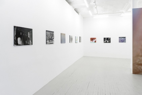 A partial view of the entire gallery. 6 color photographs on plexiglass are on the wall at left, 3 works on the back wall. At right we see an excerpt of the wallpaper created by the artist.
