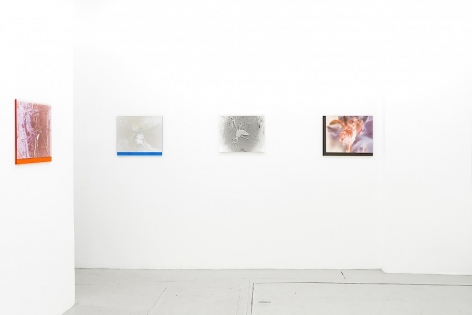 4 color photographs on plexiglass installed around the corner of the room, 1 on the left, 3 on the wall facing the viewer