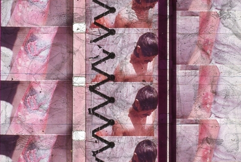 A single slide from Luther Price's video projection: there is a burnt arm depicted on two of the three columns we see. The central column has a person looking downward, seemingly wet.