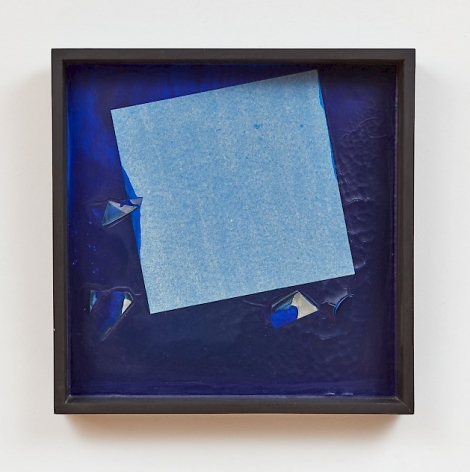 A composition with a base of thick blue paint. There is a square made of tissue paper near the center, tilted to the left. The square has taken on a slight blue hue, and there are several punctures in the bright blue that appear to be paper beneath it.