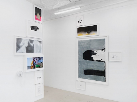 An installation image of the entryway into the gallery office, which hosts 2 columns of drawings and paintings: one on the edge of a wall, and the other directly opposite it (90-degrees). The entryway is the central line of this arrangement.